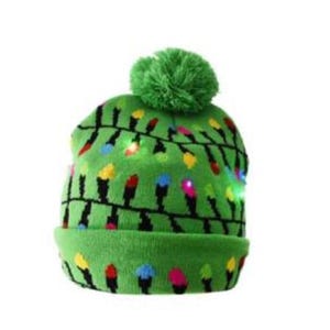 Green knit hat with multicolored Christmas light designs and a pom-pom on top. Lights are embedded along the design, illuminating in various colors for a festive look.