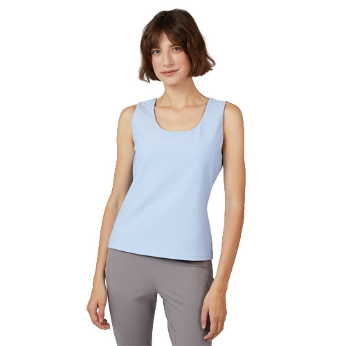A woman is wearing a light blue sleeveless top paired with gray pants.