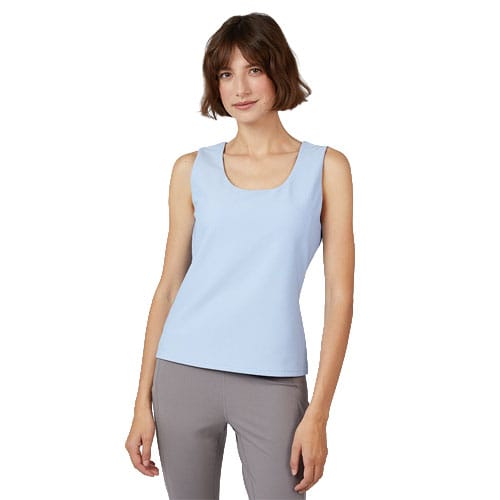 A woman is wearing a light blue sleeveless top paired with gray pants.