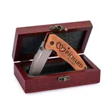 A folding knife with a wooden handle engraved with intertwined hearts, the name \“Richard,\“ and the date \“02.14.2023\“ is displayed in an open wooden box with a clasp.