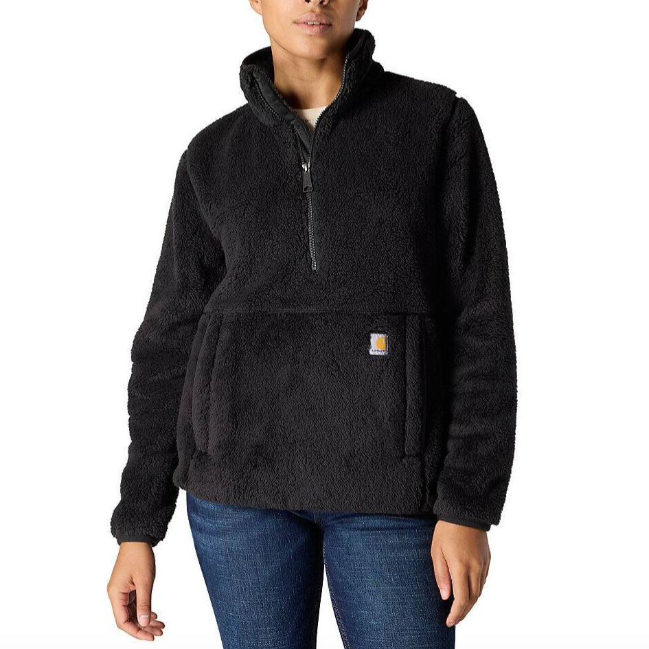 A person is wearing a black sherpa fleece pullover with a quarter-zip and front kangaroo pocket.