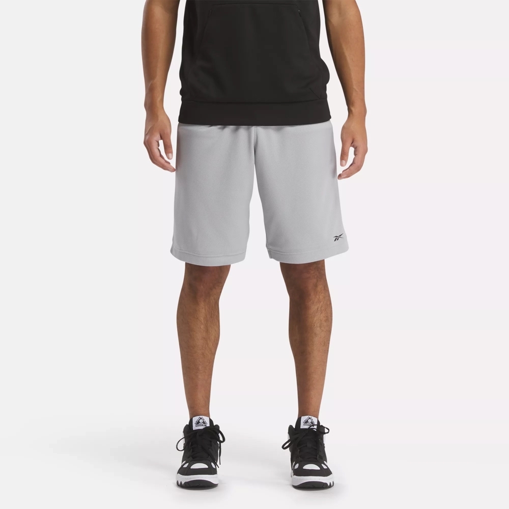 Gray knee-length athletic shorts with a small black logo on the left leg, paired with a black tank top and black sneakers.