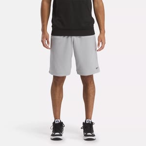 Gray knee-length athletic shorts with a small black logo on the left leg, paired with a black tank top and black sneakers.