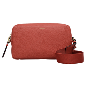 A coral crossbody bag with a pebbled leather texture and an adjustable wide strap, featuring gold-tone hardware and a simple design.