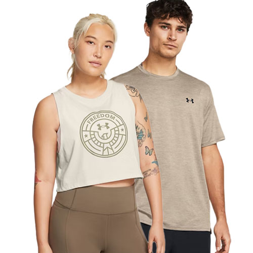 Two people wearing athletic apparel: the person on the left has a sleeveless crop top with the word \“FREEDOM\“ printed on it, while the person on the right wears a taupe Under Armour t-shirt.
