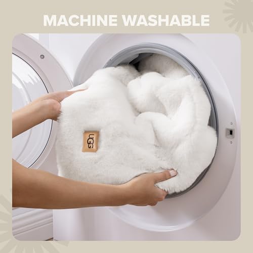 A person is placing a fluffy, white, machine-washable UGG blanket or similar textile item into a washing machine.