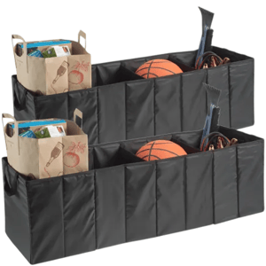 Two black collapsible trunk organizers each containing assorted items: a paper grocery bag with packaged goods, a basketball, jumper cables, and an ice scraper.