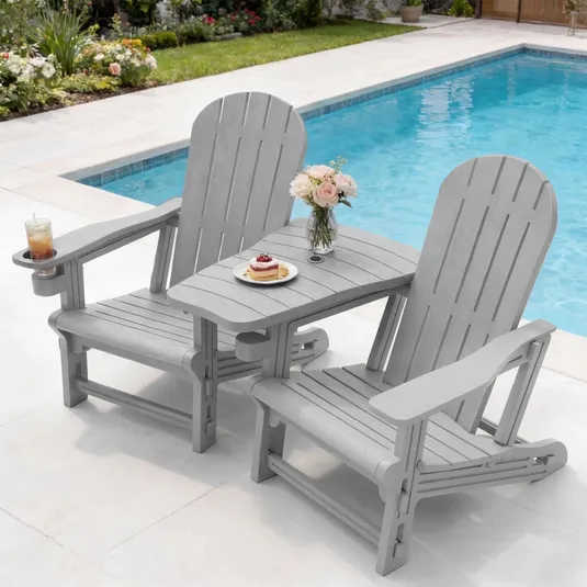 Two gray Adirondack chairs connected by a shared table with a vase of flowers and a plate of pancakes, positioned by a pool. One chair features a built-in cup holder with a glass of iced tea.