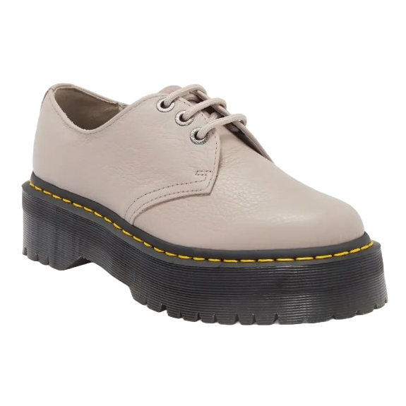 Dr. Martens Quad II Platform Derby Shoes feature a smooth, pale pink leather upper with a black chunky platform sole. They have lace-up fastening with silver eyelets and a yellow stitching detail around the sole.
