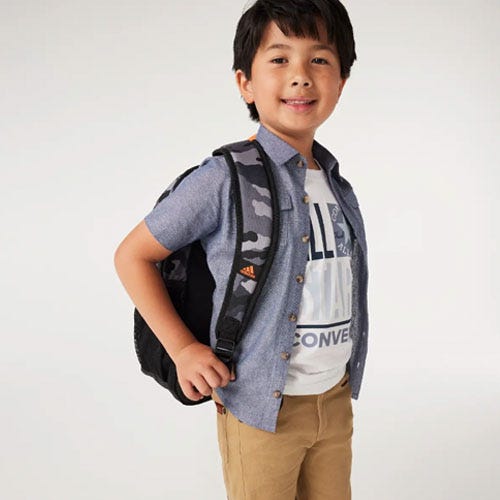 a boy wearing a blue shirt and a black backpack