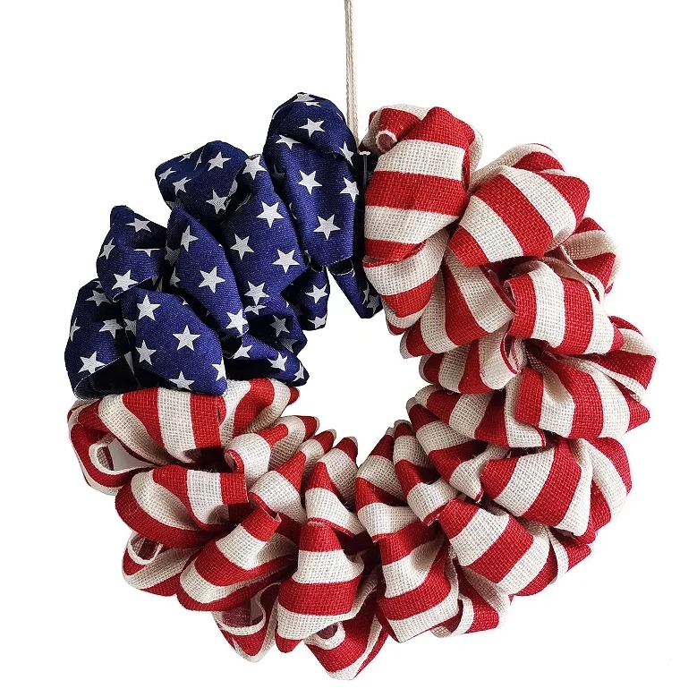 A wreath made of fabric with a design resembling the American flag, featuring stars on a blue background and red and white stripes.