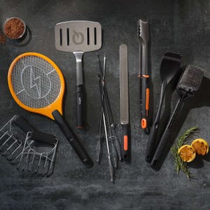 Orange and black handheld bug zapper resembling a tennis racket, featuring a mesh grid for eliminating insects.