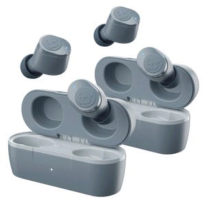 A pair of Skullcandy wireless earbuds are shown with charging cases, featuring a compact, sleek design in gray. Each earbud has a small blue indicator light and a distinctive logo, emphasizing their portable and user-friendly design.