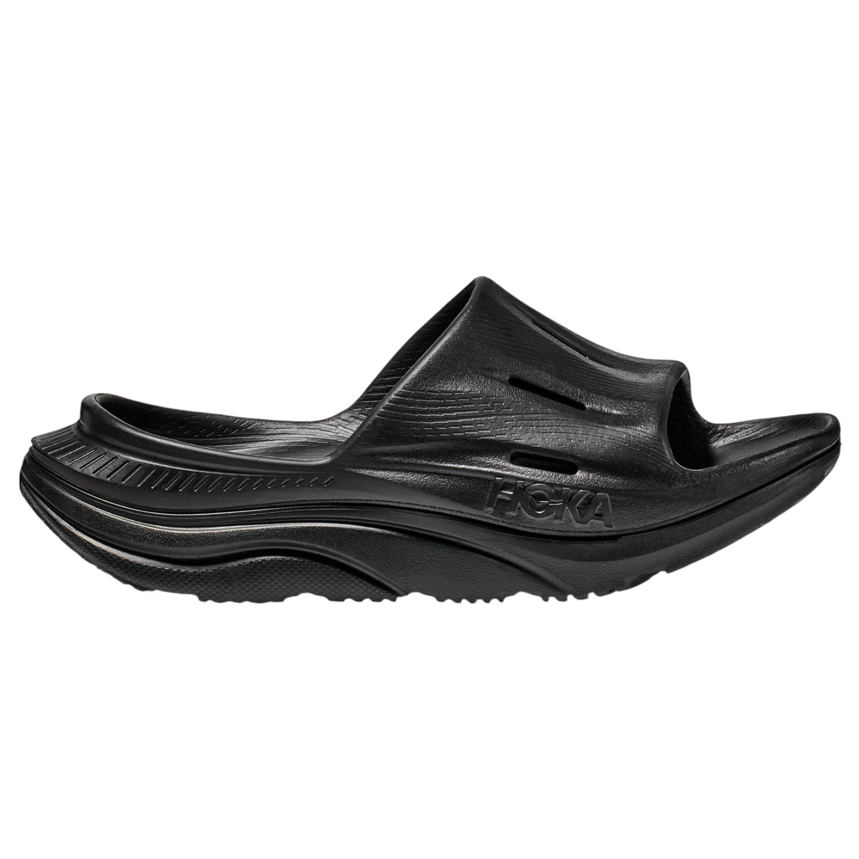 A black slide sandal with a thick sole and rounded footbed, featuring the HOKA logo on the side.