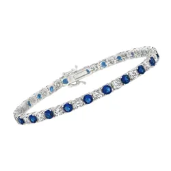 A silver tennis bracelet featuring alternating round blue and clear gemstones, secured with a clasp.