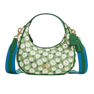 A green handbag with a floral pattern, featuring blue and green shoulder straps and gold hardware, including a Coach logo.