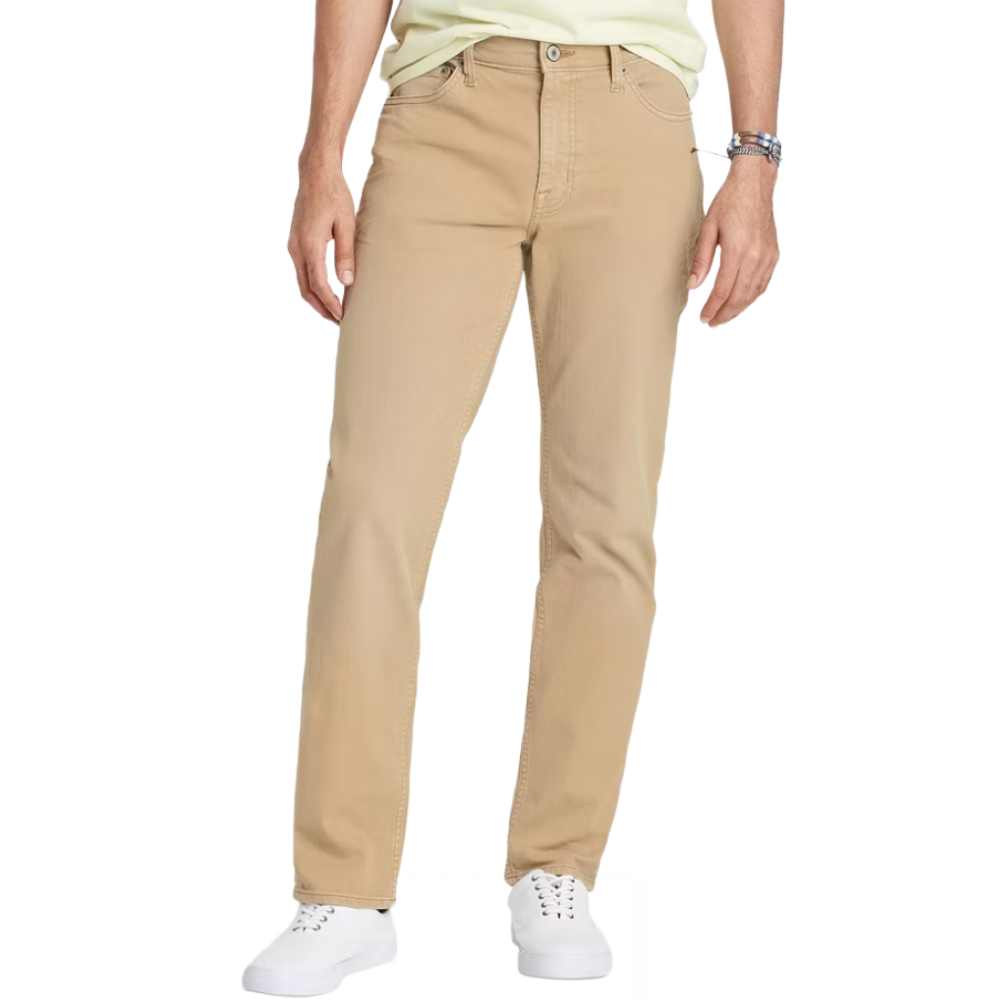 A person is wearing beige straight-leg pants paired with white sneakers and a light shirt, accessorized with a wristwatch.