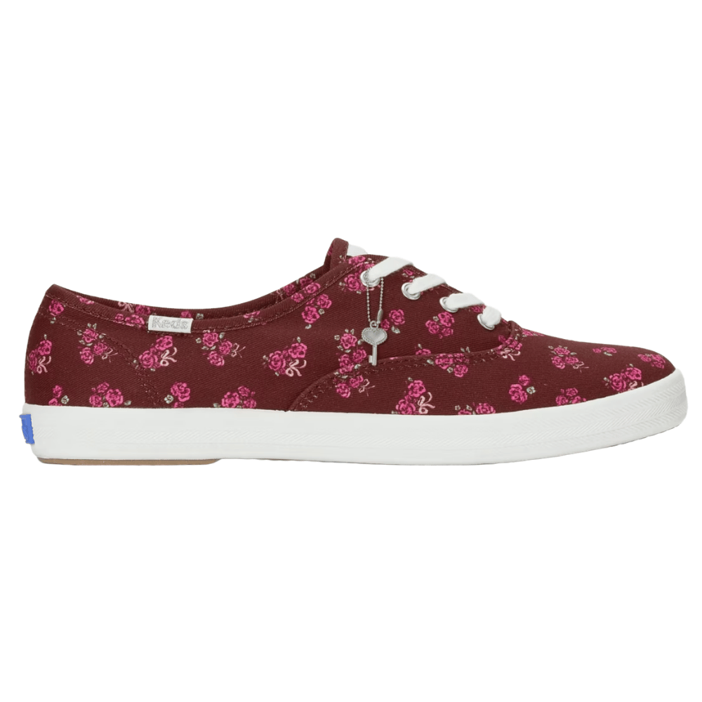 A maroon sneaker with pink floral patterns, white laces, and a white rubber sole.