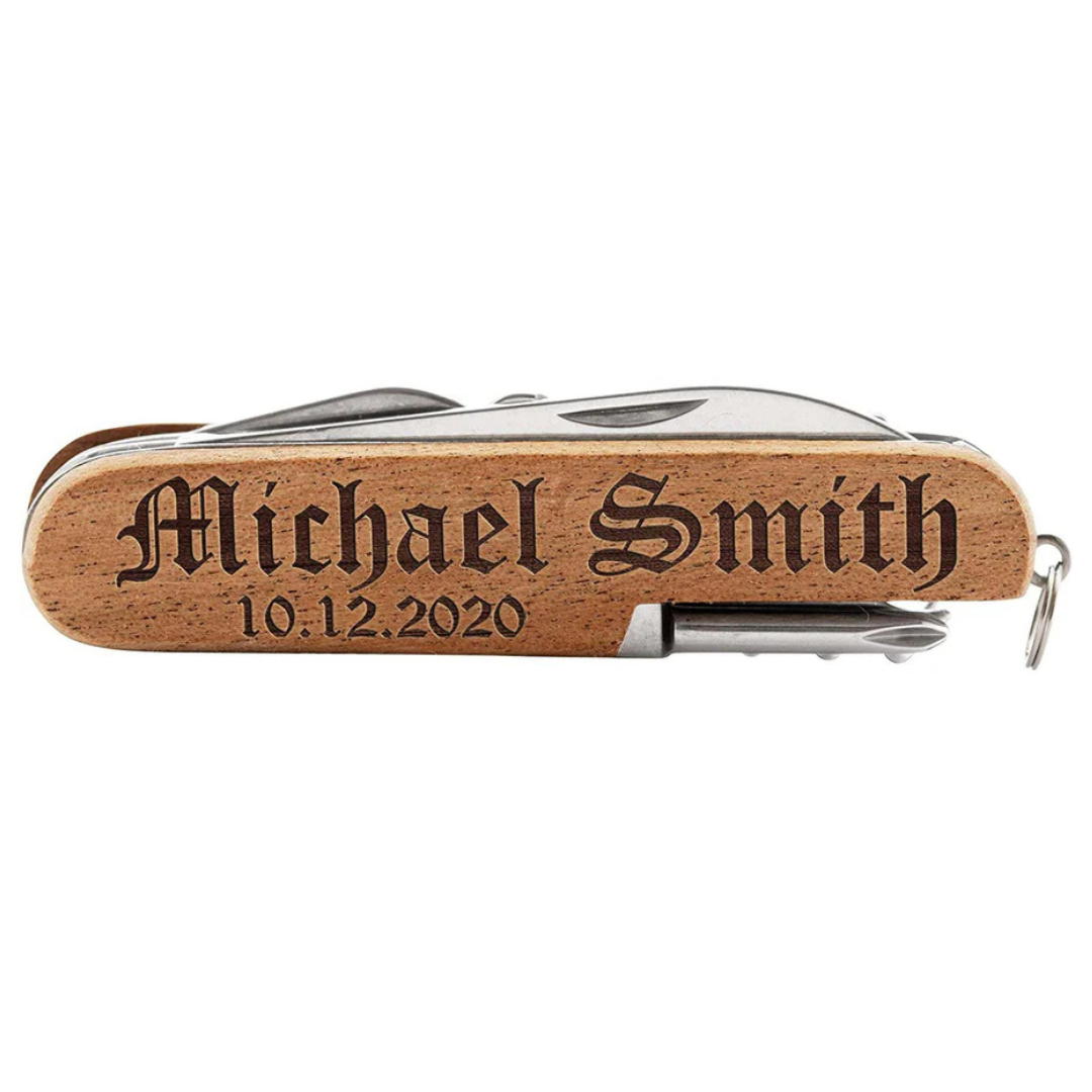 A multi-tool with a wooden handle engraved with \“Michael Smith\“ and the date \“10.12.2020\“.