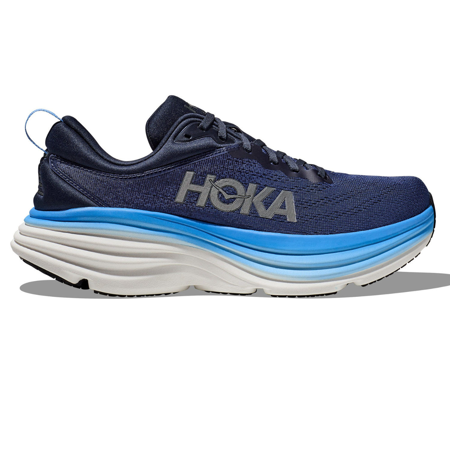 Hoka Men's Bondi 8 Shoes feature a navy upper with a large \“HOKA\“ logo, a plush white and blue midsole for cushioning, and a black outsole. They are designed for comfort with a focus on maximal cushioning.
