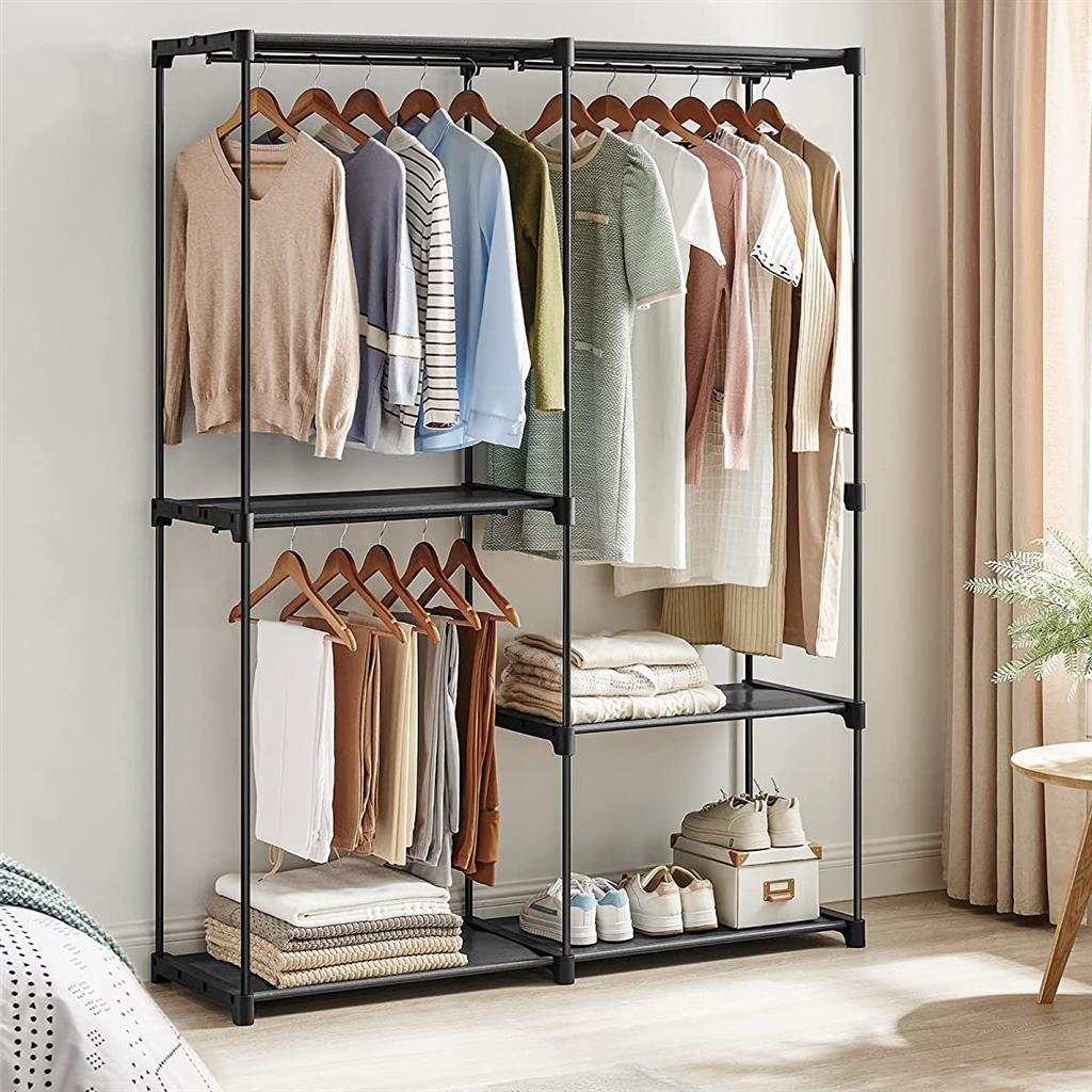 Open wardrobe with shelves and hanging space, displaying clothes, blankets, and shoes.