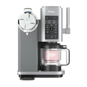 Ninja ice cream maker with a digital control panel and a milk frother attachment, designed for creating various frozen treats in a modern kitchen setup.