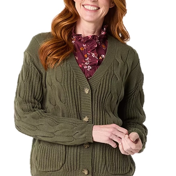A person is wearing a cable knit cardigan sweater in olive green over a maroon floral blouse.
