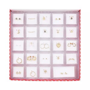 Jewelry Advent Calendar with 24 compartments featuring a mix of earrings and necklaces in various designs, including hearts, hoops, and studs, in gold and silver tones.