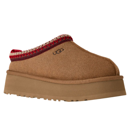 A brown slip-on shoe with a platform sole, featuring red and white stitched trim and the UGG logo embroidered on the side.