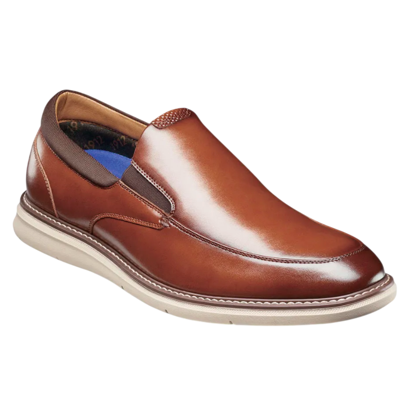A brown leather slip-on shoe with a smooth finish, featuring a cushioned sole and a subtle stitched design near the elastic side panels.