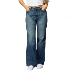 A person wears blue flared jeans and a white cropped top, paired with white sneakers.