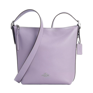 Lavender Coach Outlet leather duffle bag featuring a pebbled texture, adjustable strap, zip closure with a braided pull, and a Coach tag charm.
