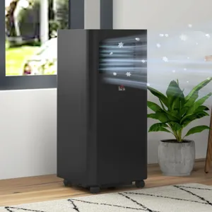 A black portable air conditioner is shown releasing cool air, placed on a wooden floor next to a potted plant near a window.