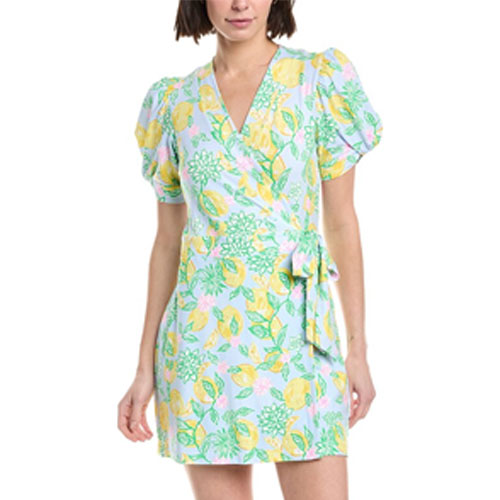 A woman wears a short, floral wrap dress with puffy short sleeves and a V-neck, featuring a pastel-colored pattern with green leaves and yellow flowers.