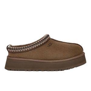 UGG Tazz Platform Slippers are brown suede slip-ons with a thick platform sole, featuring decorative stitching around the collar and a logo on the side.