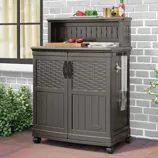 Outdoor storage cabinet with wheels, featuring two doors and a towel holder, topped with kitchen items like a cutting board and condiments.