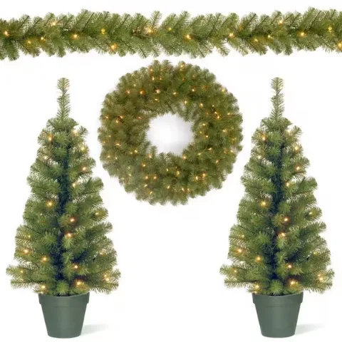 A 4-piece Christmas tree decorating set includes two small, pre-lit artificial trees in pots, a pre-lit wreath, and a pre-lit garland, all featuring green foliage with warm white lights.