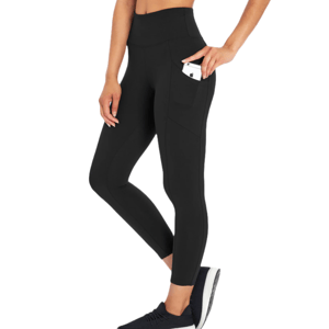 Black high-waisted leggings with pockets, holding a smartphone, worn by a person paired with black sneakers.