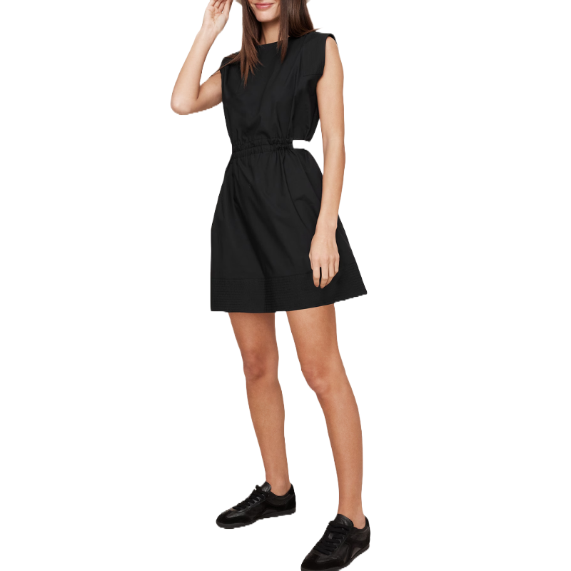 A woman is wearing a sleeveless black dress with a cinched waist, paired with black sneakers.