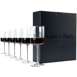 Set of six modern wine glasses with a straight-sided design, partially filled with red wine, alongside a black box labeled \“Aspen & Birch Premium Glassware.\“