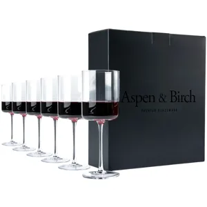 Set of six modern wine glasses with a straight-sided design, partially filled with red wine, alongside a black box labeled \“Aspen & Birch Premium Glassware.\“