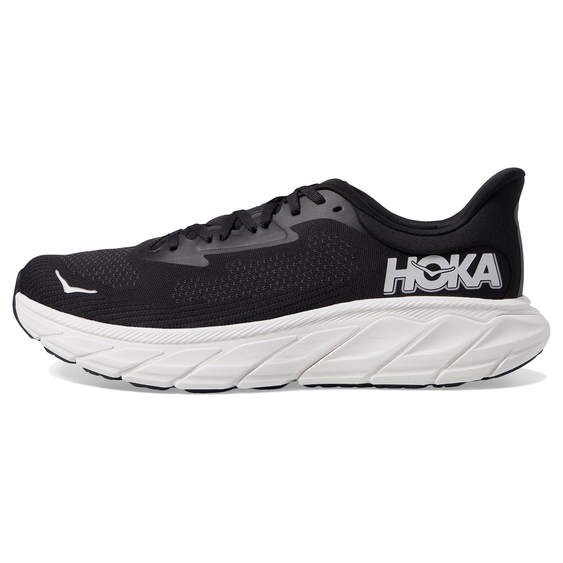 A black and white running shoe with a thick, cushioned sole, featuring the HOKA logo on the side. The design is streamlined with breathable material.