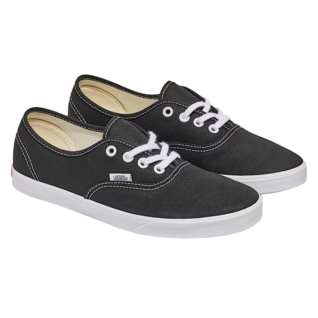 A pair of black Vans sneakers with white laces and soles, featuring visible stitching and the Vans logo on the side.