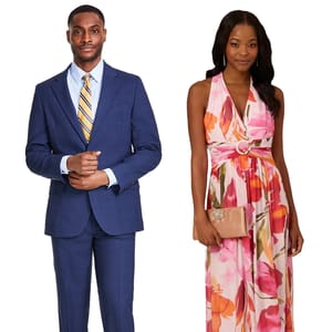 A man in a blue suit with a striped yellow tie and a woman in a pink floral halter dress holding a beige clutch.