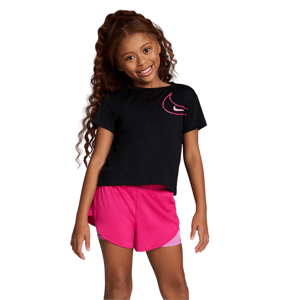 A young girl smiles wearing a black T-shirt with a pink logo and bright pink shorts.