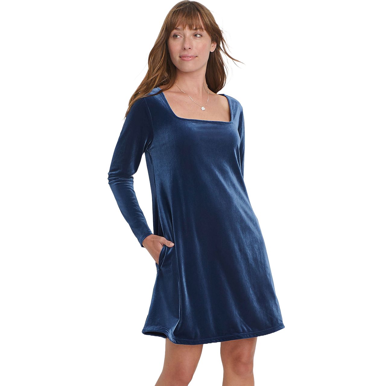 A woman wears a blue velvet dress with long sleeves and a square neckline. The dress has a loose fit and features pockets on the sides.