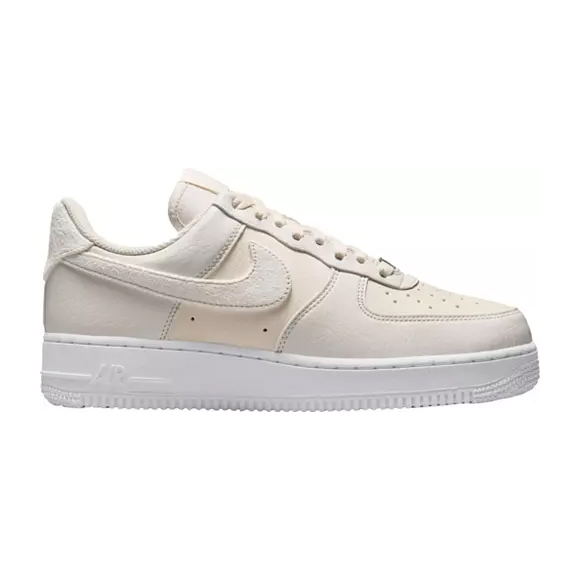 A low-top, cream-colored sneaker with a white sole and a Nike swoosh logo on the side.