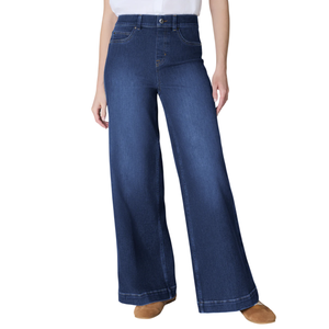 Wide-leg denim jeans with a high waist, contrasted with a white tucked-in shirt and brown shoes.