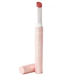 A Tarte Maracuja Juicy Lip Crème lipstick in a light pink tube with the cap off, revealing a rose-colored product.