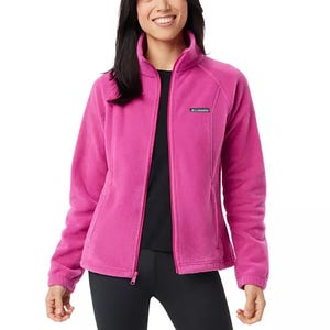 Woman wearing a pink fleece jacket with a stand-up collar and zipper front.